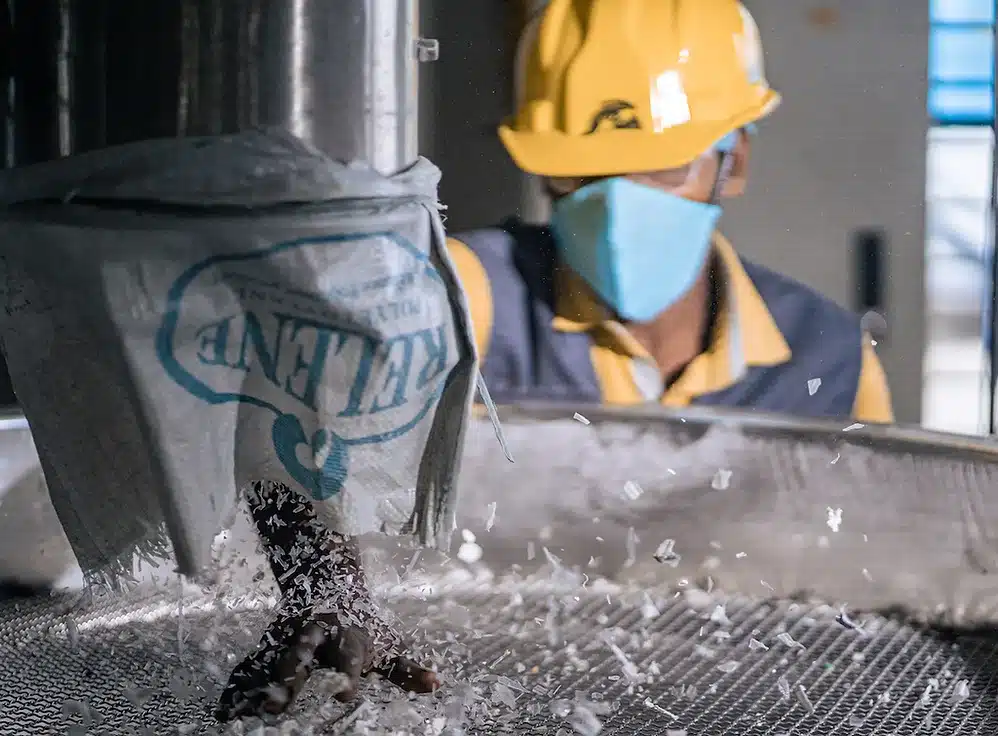 Photograph of man in yellow hardhat working at machine